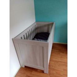 Nette lichtgrijze babykamer.